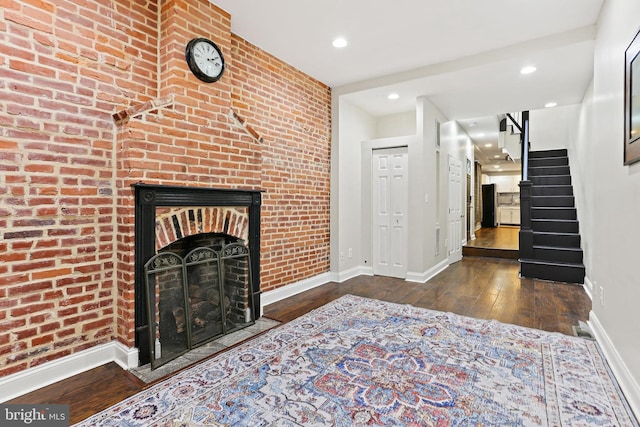 3016 Dillon St, Baltimore, MD 21224 - living area with hardwood / wood-style flooring, stairs, recessed lighting, a fireplace, and brick wall