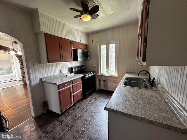 2326 Franklin Ave, Morton, PA 19070 - kitchen with black / electric stove, stainless steel microwave, radiator, a ceiling fan, and arched walkways