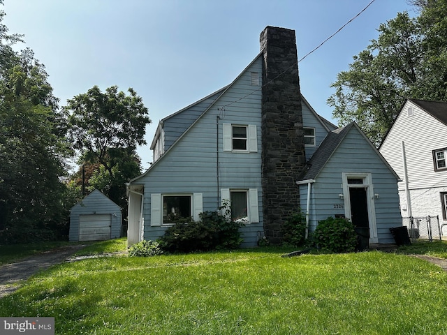 2326 Franklin Ave, Morton, PA 19070 - view of front of house featuring a chimney, a front yard, an outdoor structure, asphalt driveway, and a detached garage