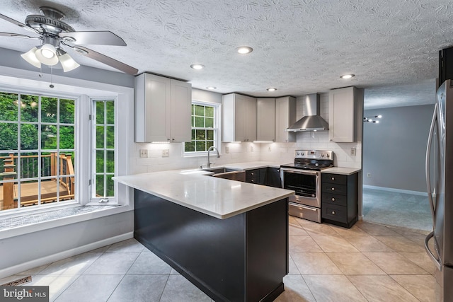 1240 Windmill Ln, Silver Spring, MD 20905 - kitchen with stainless steel appliances, wall chimney range hood, a peninsula, a ceiling fan, and decorative backsplash