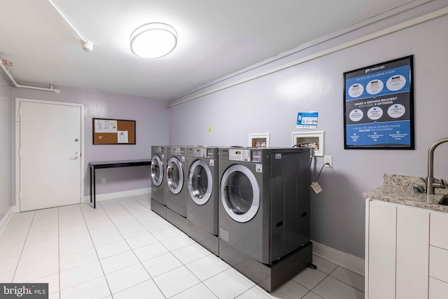 2001 Hamilton St Unit 925, Philadelphia, PA 19130 - laundry room featuring separate washer and dryer, cabinet space, and light tile patterned floors