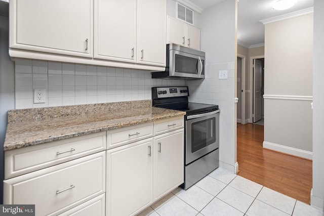 1901 John F Kennedy Blvd Unit 1414, Philadelphia, PA 19103 - kitchen with stainless steel appliances, ornamental molding, white cabinetry, decorative backsplash, and light tile patterned flooring