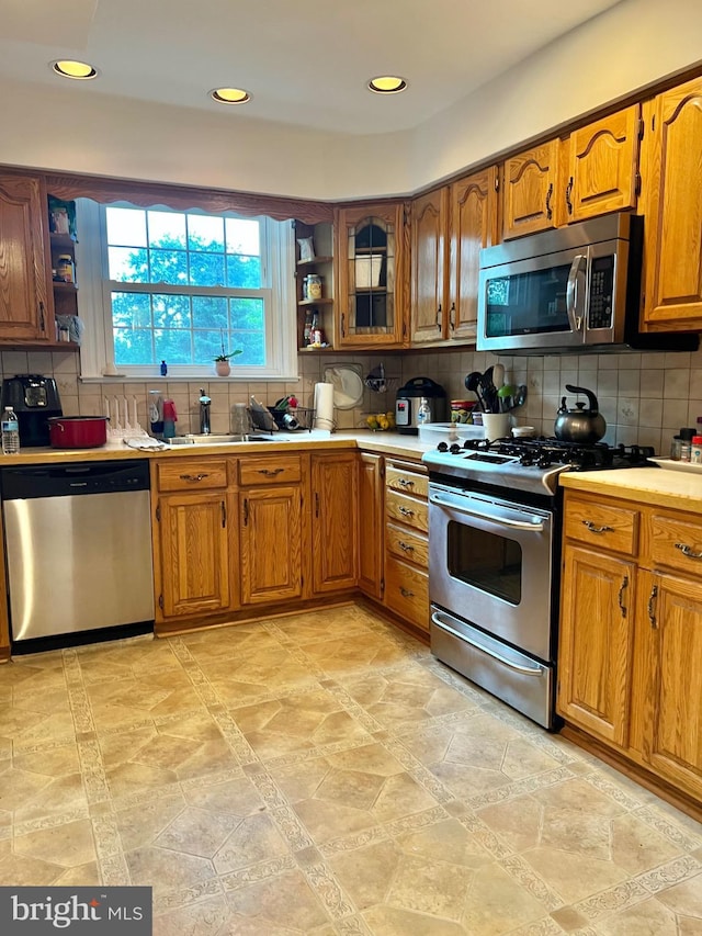 9013 Ashton Rd, Philadelphia, PA 19136 - kitchen with appliances with stainless steel finishes, open shelves, brown cabinets, tasteful backsplash, and recessed lighting
