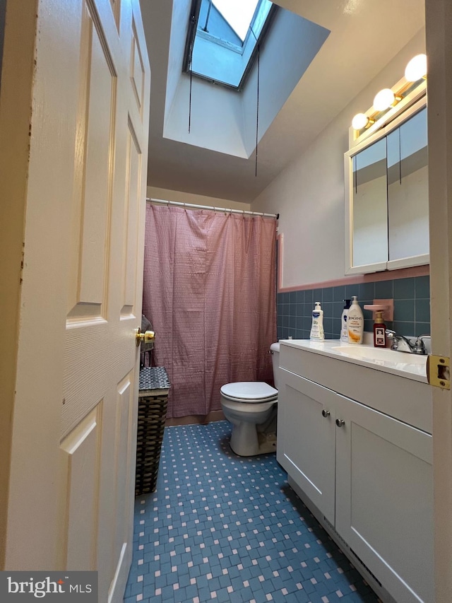 9013 Ashton Rd, Philadelphia, PA 19136 - full bath featuring a skylight, vanity, curtained shower, tile walls, and a wainscoted wall
