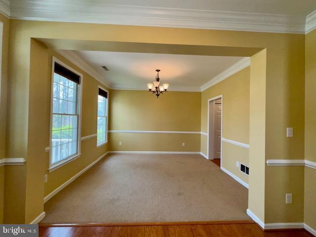 12410 Coastal Marsh Dr, Berlin, MD 21811 - empty room with a chandelier, crown molding, and wood finished floors