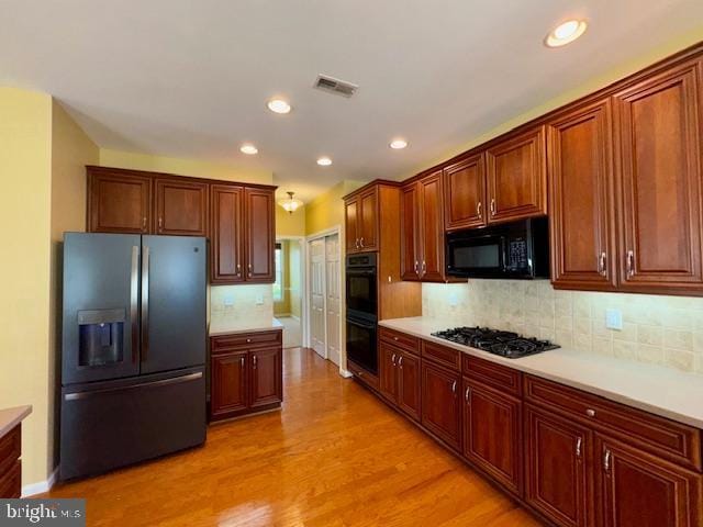 12410 Coastal Marsh Dr, Berlin, MD 21811 - kitchen with black appliances, light countertops, light wood finished floors, recessed lighting, and tasteful backsplash