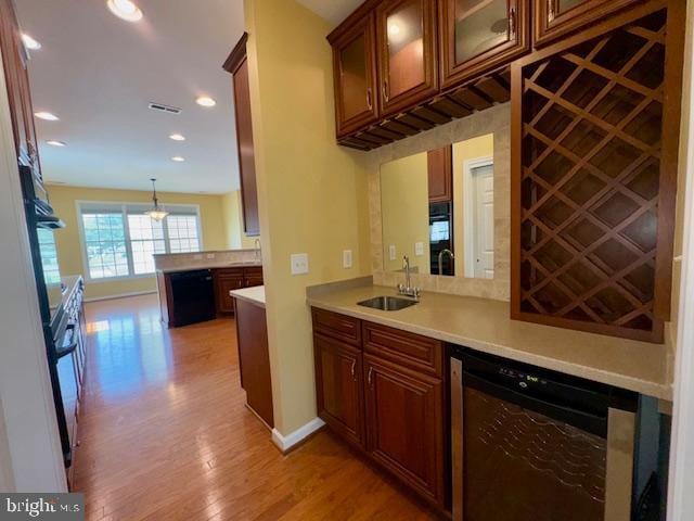 12410 Coastal Marsh Dr, Berlin, MD 21811 - kitchen with wine cooler, light wood-style flooring, black appliances, light countertops, and recessed lighting