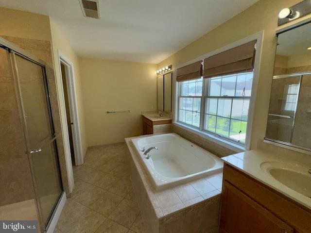 12410 Coastal Marsh Dr, Berlin, MD 21811 - full bathroom with two vanities, a shower stall, a garden tub, and tile patterned flooring