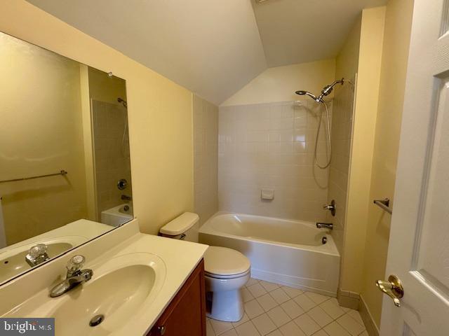 12410 Coastal Marsh Dr, Berlin, MD 21811 - bathroom featuring tile patterned flooring, vaulted ceiling, vanity, and shower / bathtub combination