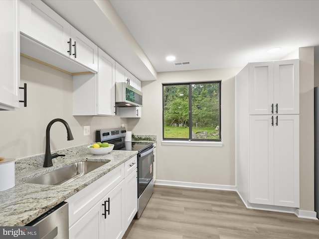 9124 Goldamber Garth, Columbia, MD 21045 - kitchen featuring appliances with stainless steel finishes, light stone counters, white cabinets, light wood finished floors, and recessed lighting