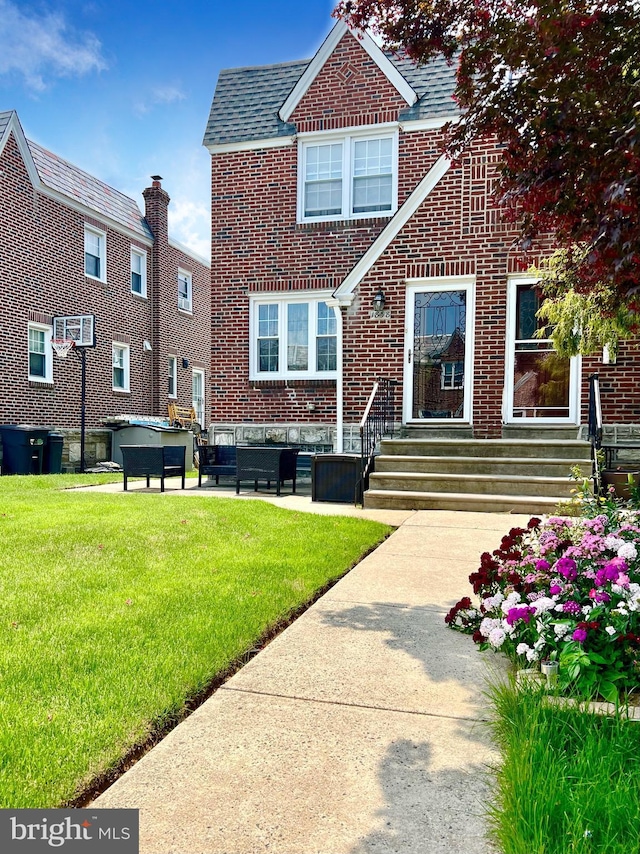 1838 Benson St, Philadelphia, PA 19152 - back of house featuring a jacuzzi, brick siding, and a lawn