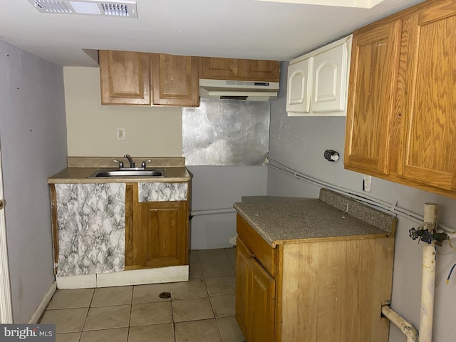 2133 Seneca Rd, Wilmington, DE 19805 - kitchen featuring under cabinet range hood, light tile patterned flooring, and brown cabinetry