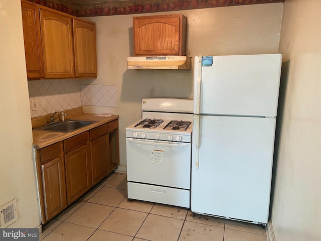 2133 Seneca Rd, Wilmington, DE 19805 - kitchen featuring white appliances, under cabinet range hood, tasteful backsplash, light tile patterned flooring, and light countertops