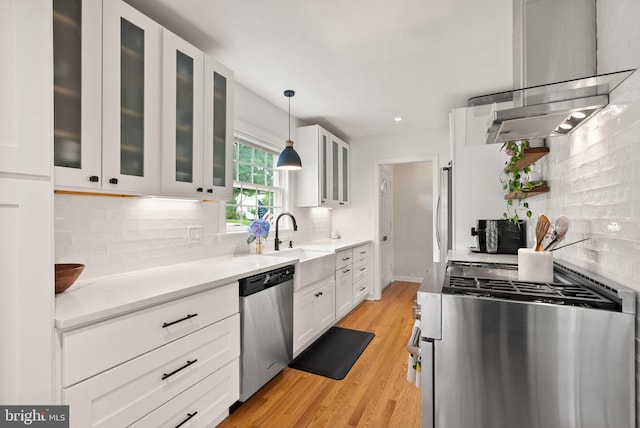 6018 25th Rd N, Arlington, VA 22207 - kitchen featuring appliances with stainless steel finishes, wall chimney exhaust hood, white cabinetry, decorative backsplash, and recessed lighting