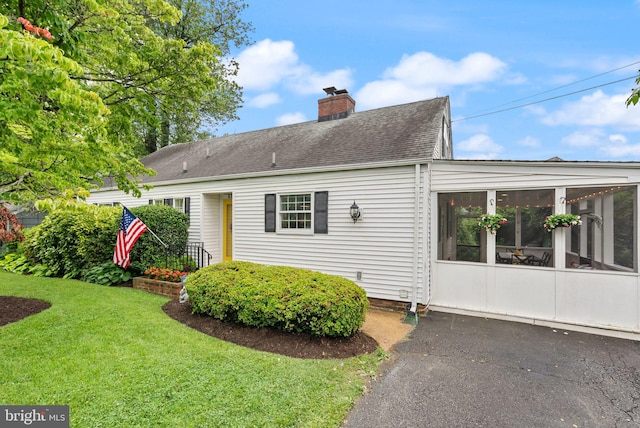 6018 25th Rd N, Arlington, VA 22207 - view of property exterior featuring a sunroom, a chimney, a yard, and a shingled roof