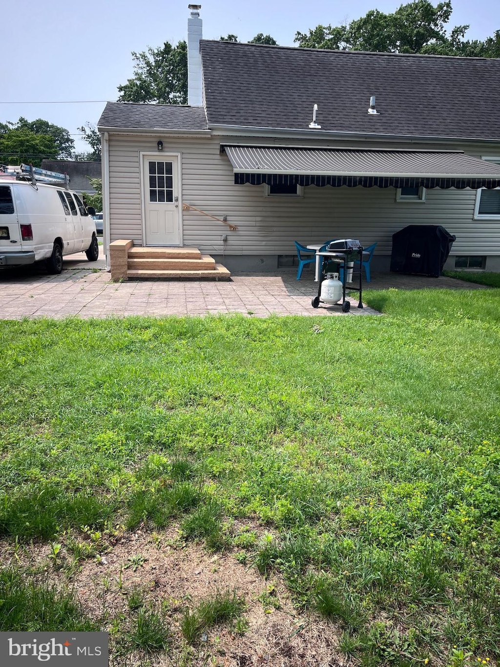 40 Fogarty Dr, Hamilton, NJ 08619 - back of house featuring a yard, a shingled roof, and a chimney