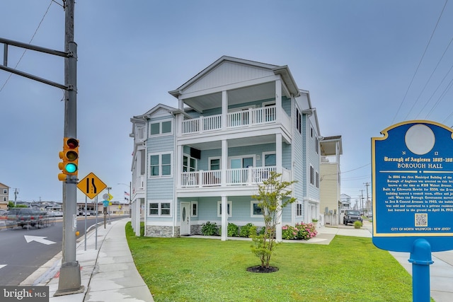 209 N New York Ave Unit 2, North Wildwood, NJ 08260 - view of front of house with a front lawn and a balcony