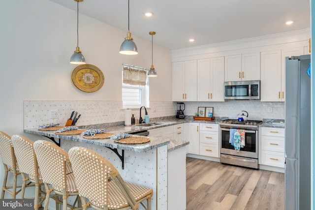209 N New York Ave Unit 2, North Wildwood, NJ 08260 - kitchen with stainless steel appliances, a peninsula, white cabinets, decorative backsplash, and light stone counters