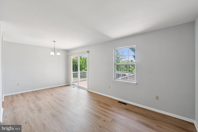 6 Flower Hill Ct, Gaithersburg, MD 20879 - spare room featuring a chandelier and light wood-style floors