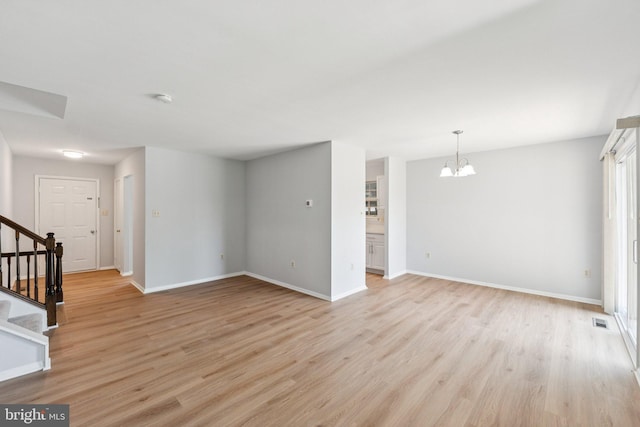 6 Flower Hill Ct, Gaithersburg, MD 20879 - unfurnished room featuring a chandelier, stairway, light wood-style flooring, and a smoke detector