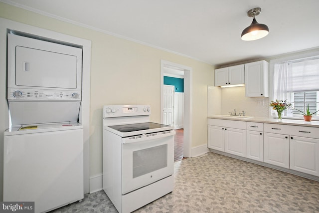 322 W End Ave, Cambridge, MD 21613 - kitchen with white electric range oven, stacked washer and clothes dryer, white cabinets, ornamental molding, and light countertops
