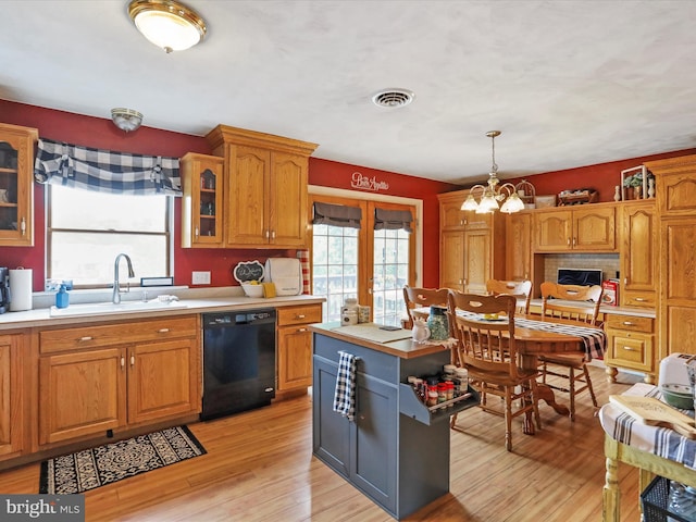 15606 Winslow St SW, Cresaptown, MD 21502 - kitchen with black dishwasher, light countertops, light wood-style floors, a chandelier, and glass insert cabinets