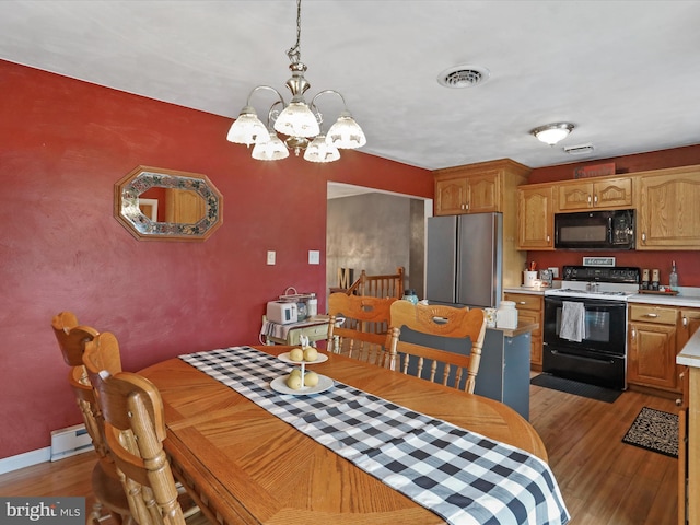 15606 Winslow St SW, Cresaptown, MD 21502 - dining room featuring wood finished floors, a chandelier, and a baseboard heating unit