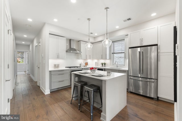 417 4th St SE Unit 2, Washington, DC 20003 - kitchen featuring high quality fridge, wall chimney range hood, dark wood-type flooring, a kitchen bar, and a kitchen island