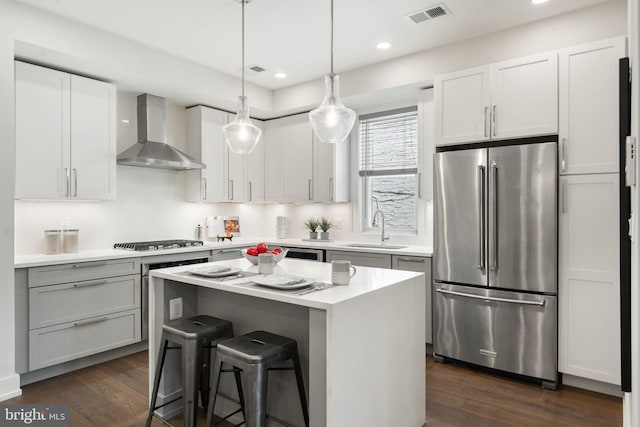 417 4th St SE Unit 2, Washington, DC 20003 - kitchen with appliances with stainless steel finishes, wall chimney range hood, a center island, dark wood-type flooring, and recessed lighting