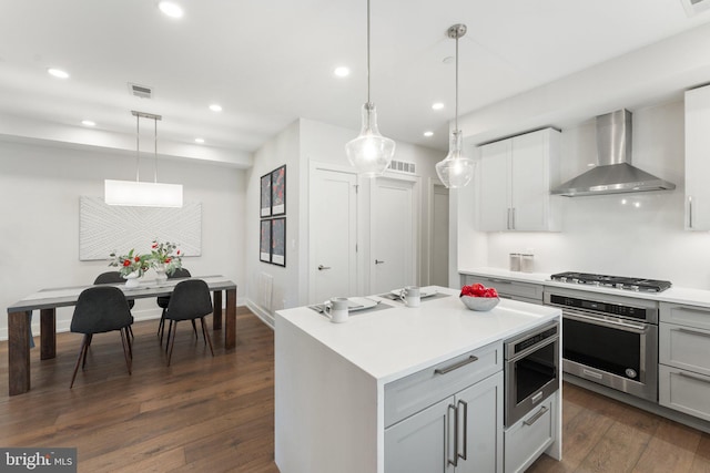 417 4th St SE Unit 2, Washington, DC 20003 - kitchen with wall chimney exhaust hood, appliances with stainless steel finishes, dark wood-style floors, recessed lighting, and light countertops