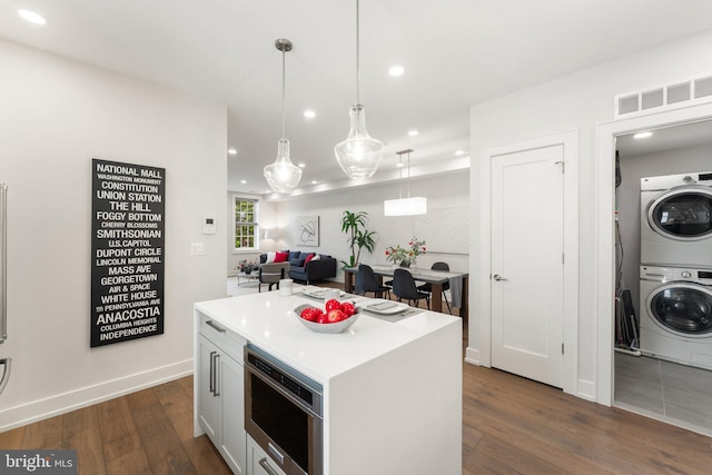 417 4th St SE Unit 2, Washington, DC 20003 - kitchen with stacked washer / dryer, dark wood-style flooring, light countertops, recessed lighting, and a kitchen island