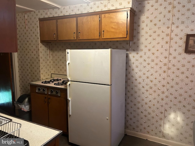 3532 Primrose Rd, Philadelphia, PA 19114 - kitchen featuring freestanding refrigerator, wallpapered walls, light countertops, and brown cabinetry
