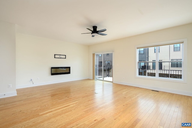 407 Fennel Rd, Crozet, VA 22932 - unfurnished living room with ceiling fan, a glass covered fireplace, and light wood-style flooring