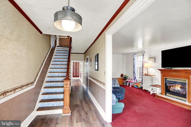 123 N 2nd St, Newport, PA 17074 - stairway with wallpapered walls, ornamental molding, a glass covered fireplace, and wood finished floors