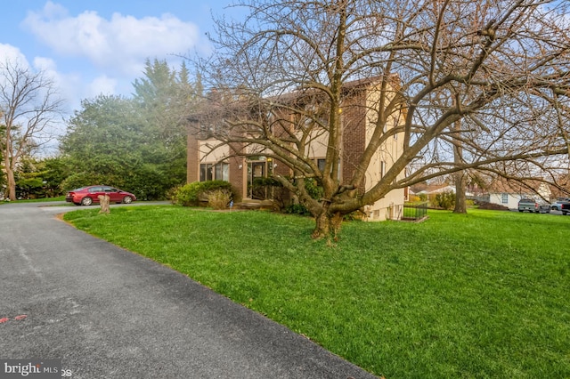 7617 Seven Mile Ln, Baltimore, MD 21208 - view of property hidden behind natural elements featuring a front lawn and stucco siding