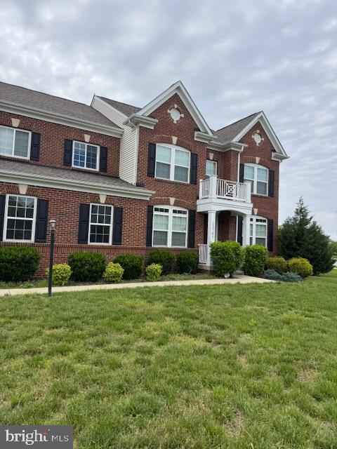 12701 Coventry Manor Way, Upper Marlboro, MD 20772 - colonial-style house featuring brick siding, a balcony, and a front yard