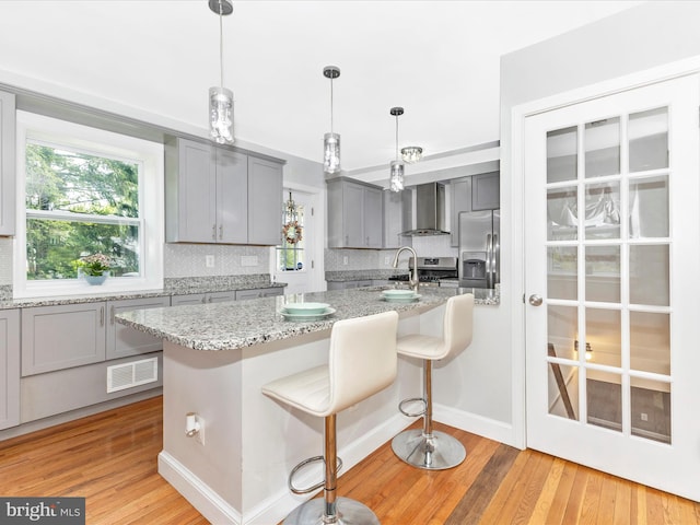 507 Kerwin Ct, Silver Spring, MD 20901 - kitchen with gray cabinetry, wall chimney exhaust hood, stainless steel fridge, and decorative backsplash