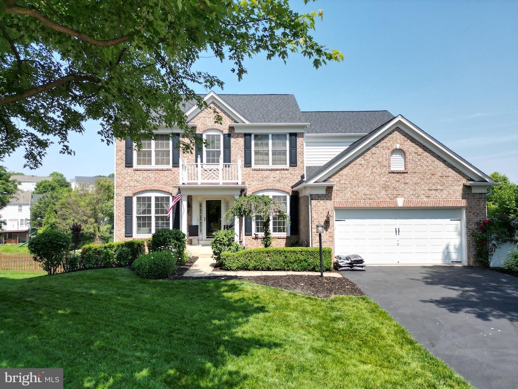 7540 Millpond Ct, Warrenton, VA 20187 - colonial house featuring asphalt driveway, a garage, a front lawn, and brick siding