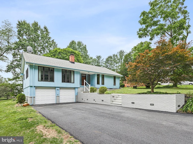 261 W Chestnut Hill Rd, Newark, DE 19713 - view of front facade featuring a garage, a chimney, asphalt driveway, roof with shingles, and a front yard