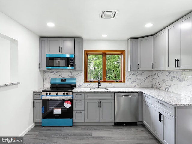 261 W Chestnut Hill Rd, Newark, DE 19713 - kitchen featuring stainless steel appliances, gray cabinetry, light stone counters, recessed lighting, and decorative backsplash