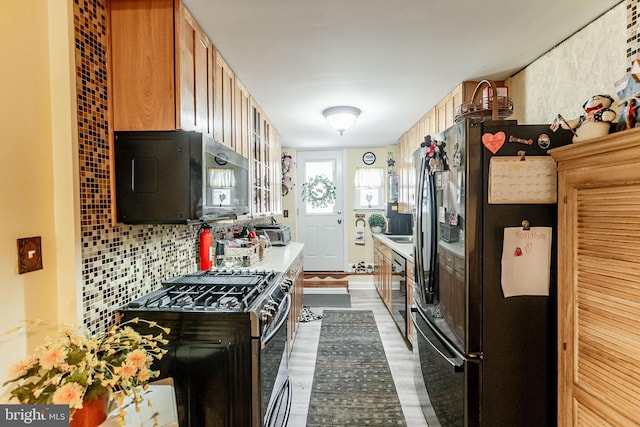 1512 S 2nd St, Philadelphia, PA 19147 - kitchen with freestanding refrigerator, black microwave, range with gas stovetop, light countertops, and wood finished floors
