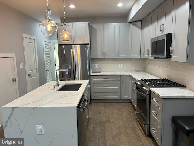 1253 Mount Olivet Rd NE Unit 3, Washington, DC 20002 - kitchen featuring appliances with stainless steel finishes, gray cabinetry, dark wood finished floors, an island with sink, and light stone counters