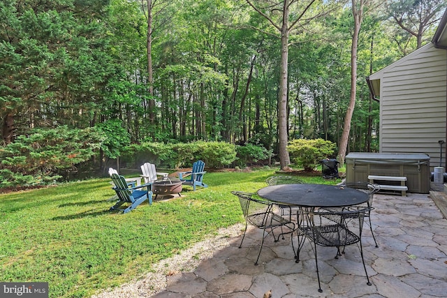4 Bunkers Ct, Grasonville, MD 21638 - view of patio / terrace with a hot tub, a fire pit, outdoor dining area, and a wooded view