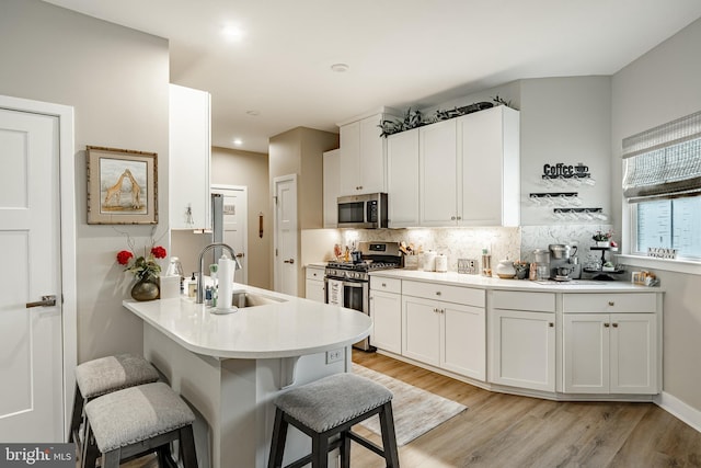 621 Thomas Penn Dr, West Grove, PA 19390 - kitchen featuring appliances with stainless steel finishes, a kitchen bar, tasteful backsplash, white cabinetry, and recessed lighting