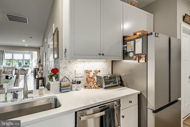 621 Thomas Penn Dr, West Grove, PA 19390 - kitchen featuring appliances with stainless steel finishes, decorative backsplash, light countertops, white cabinets, and recessed lighting