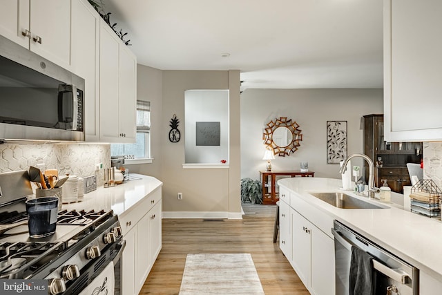 621 Thomas Penn Dr, West Grove, PA 19390 - kitchen with stainless steel appliances, light wood-style floors, tasteful backsplash, and light countertops