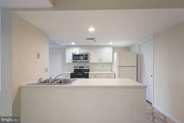 1967 Superfine Ln # 87, Wilmington, DE 19802 - kitchen with stainless steel microwave, electric range, freestanding refrigerator, a peninsula, and light countertops