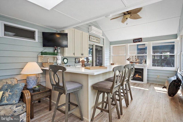 352 Ocean, Ocean Pines, MD 21811 - kitchen with a wall mounted AC, a kitchen bar, light wood-type flooring, a ceiling fan, and light countertops