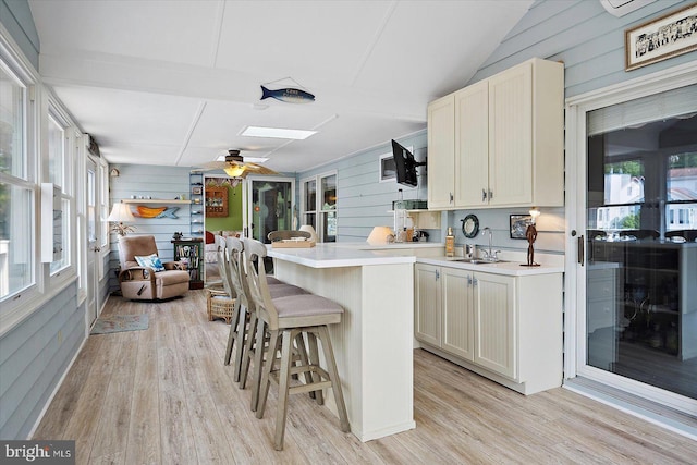 352 Ocean, Ocean Pines, MD 21811 - kitchen featuring wood walls, a kitchen bar, light wood-type flooring, light countertops, and lofted ceiling