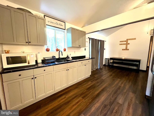 4650 Dywer Ave, Millville, NJ 08332 - kitchen with white microwave, vaulted ceiling, dark countertops, and dark wood finished floors